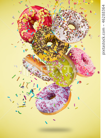 Tasty doughnuts in motion falling on pastel blue background. Tasty doughnuts in motion falling on pastel blue background. 46288364