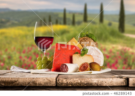 Delicious cheeses with wine on old wooden table. Delicious cheeses with wine on old wooden table. 46289143