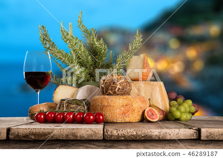Delicious cheeses with wine on old wooden table. Delicious cheeses with wine on old wooden table. 46289187