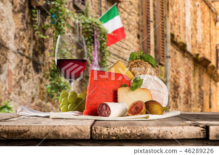 Delicious cheeses with wine on old wooden table. Delicious cheeses with wine on old wooden table. 46289226