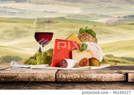 Delicious cheeses with wine on old wooden table. Delicious cheeses with wine on old wooden table. 46289227