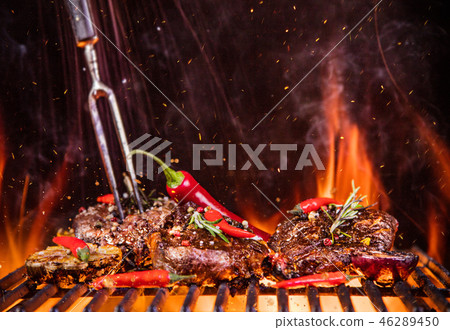 Beef steaks on the grill with flames 46289450