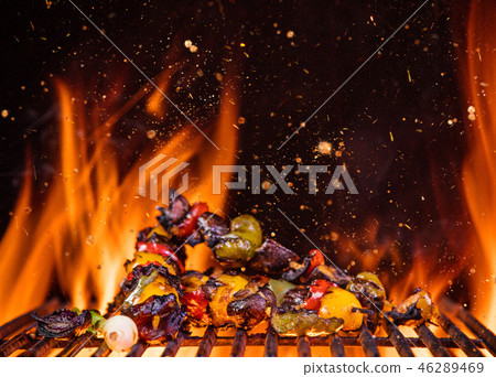 Chicken skewers on the grill with flames Chicken skewers on the grill with flames 46289469
