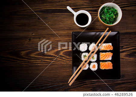 Various kinds of sushi served on wooden table. 46289526