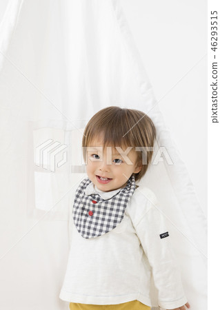 Infant boy playing in an indoor tent 46293515