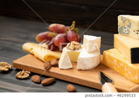 Various types of cheese on a rustic table 46299533