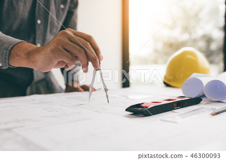 Engineering man hand drawing on blueprint on desk. 46300093