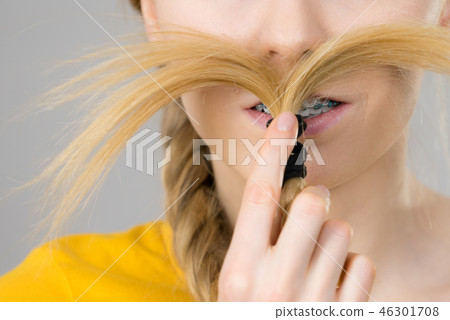 Woman making moustache out of blonde hair Woman making moustache out of blonde hair 46301708
