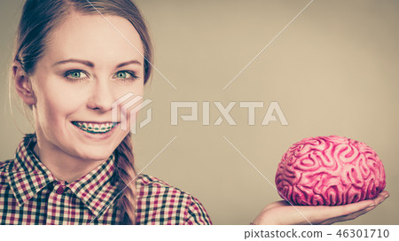 Woman thinking and holding fake brain Woman thinking and holding fake brain 46301710