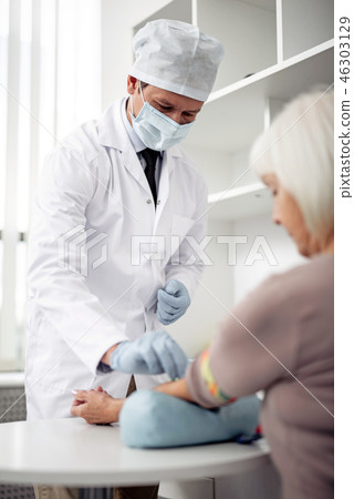Doctor wearing medical mask and making injection 46303129
