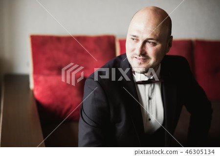 Grooms morning preparation. Handsome man getting dressed and preparing for the wedding 46305134