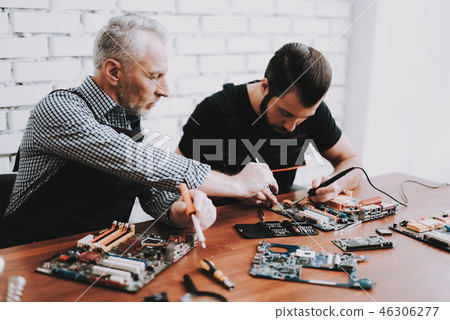 Two Men Repairing Hardware Equipment from PC. Two Men Repairing Hardware Equipment from PC. 46306277