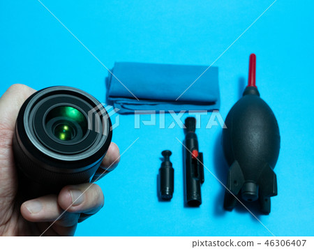 hand with photography lens and cleaning tools hand with photography lens and cleaning tools 46306407