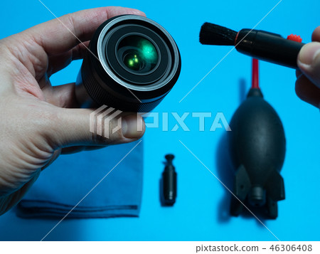 service man holding lens and dust brush service man holding lens and dust brush 46306408