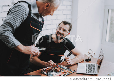 Two Men Repairing Hardware Equipment in Workshop. 46306631