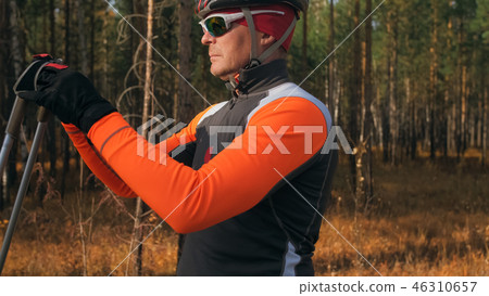 Training an athlete on the roller skaters. Biathlon ride on the roller skis with ski poles, in the 46310657