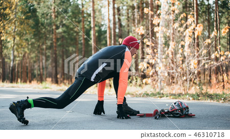Training an athlete on the roller skaters. Biathlon ride on the roller skis with ski poles, in the 46310718
