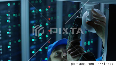 Technician installing security camera Technician installing security camera 46312745
