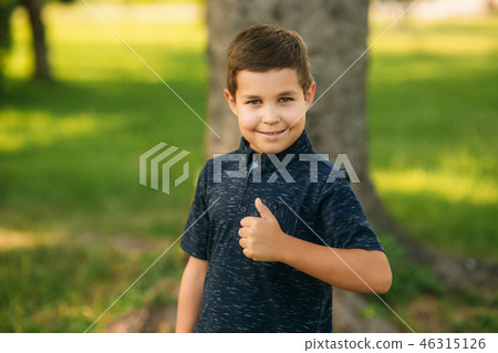 Cheerful boy spent time in park. Ten year old child smile and have fun Cheerful boy spent time in park. Ten year old child smile and have fun 46315126