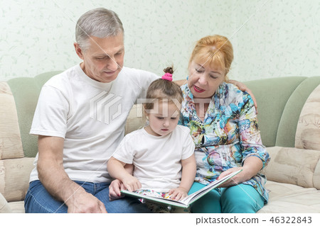 Grandmother and grandfather with granddaughter on couch Grandmother and grandfather with granddaughter on couch 46322843