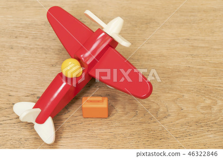 miniature suitcase and toy plane on table miniature suitcase and toy plane on table 46322846