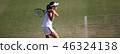 Junior tennis player hitting backhand stroke on natural turf court 46324138