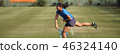 Junior tennis player serving on a natural turf court 46324140