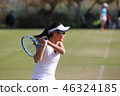 Junior tennis player hitting backhand stroke on natural turf court 46324185