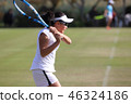 Junior tennis player hitting backhand stroke on natural turf court 46324186
