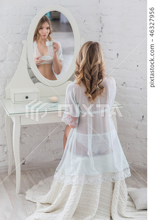 Gentle girl in elegant lingerie in front of the mirror Gentle girl in elegant lingerie in front of the mirror 46327956