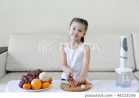 The child cuts apples with a knife. 46328166