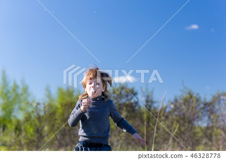 child blowing dandelion 46328778