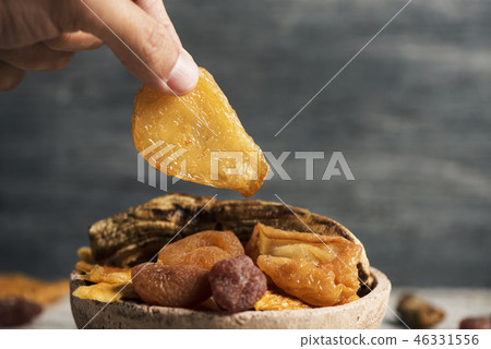 man taking a piece of dried pear man taking a piece of dried pear 46331556