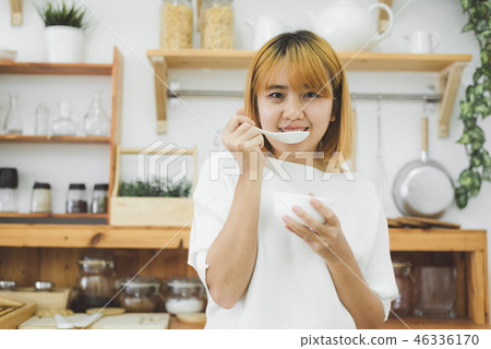 woman holding pumpkin cream soup in kitchen. 46336170