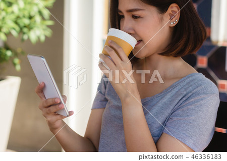 woman drink coffee and using smartphone in cafe. woman drink coffee and using smartphone in cafe. 46336183