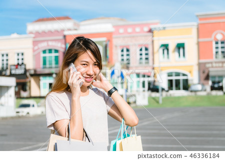 woman using smartphone with shopping bags. woman using smartphone with shopping bags. 46336184