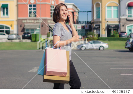 woman using smartphone with shopping bags. woman using smartphone with shopping bags. 46336187