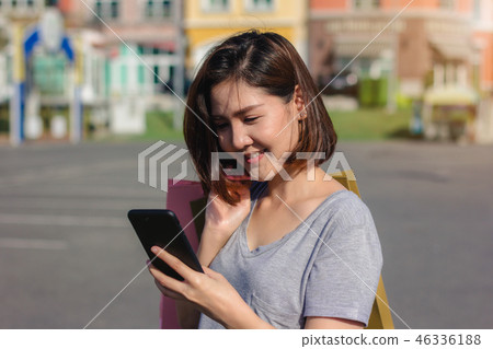 woman using smartphone with shopping bags. woman using smartphone with shopping bags. 46336188