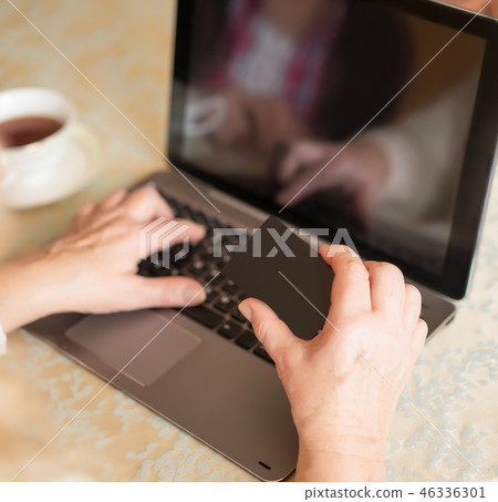Close-up view of senior woman using credit card for online shopping Close-up view of senior woman using credit card for online shopping 46336301