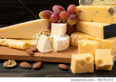 Various types of cheese on a rustic table 46345355