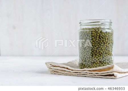 Glass storage jar full of dried green mung beans 46346933