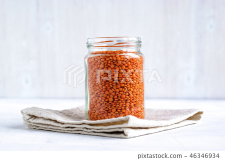 Glass jar filled with orange or red lentils 46346934