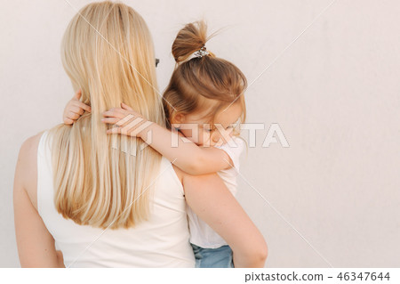 Beautiful mothe with her daughter. Blond hair female. Gray background. Best friends Beautiful mothe with her daughter. Blond hair female. Gray background. Best friends 46347644
