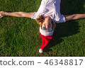 woman in Santa Claus hat on green grass.  46348817