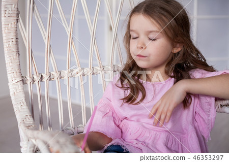 beautiful little girl drinking milk shakes in an armchair vacation 46353297