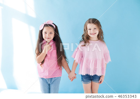 two little girls are sisters girlfriends in a pink dress two little girls are sisters girlfriends in a pink dress 46353343