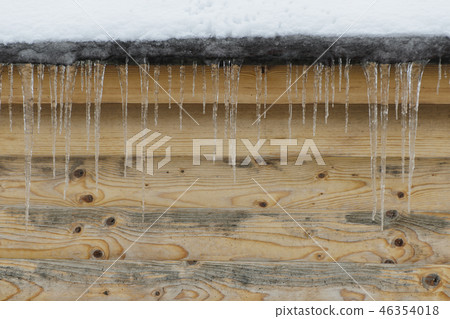 Icicles on a background of brown wooden wal Icicles on a background of brown wooden wal 46354018