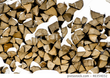 Chopped firewood on a stack in snow. Front view. 46354032