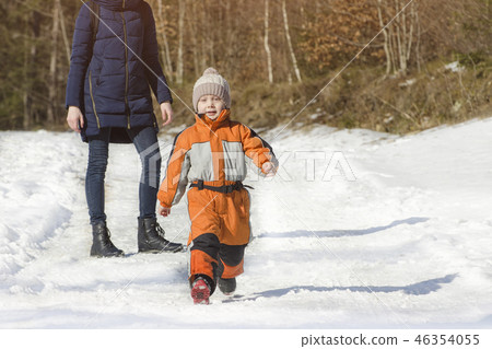 Little boy in overalls runs away from his mother Little boy in overalls runs away from his mother 46354055