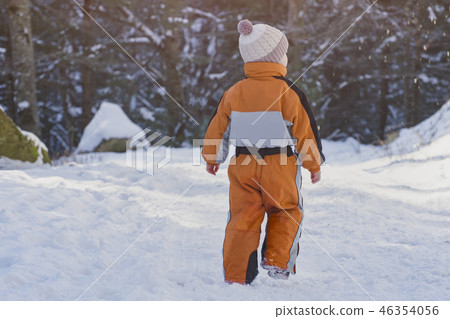 Little boy in an orange jumpsuit walking 46354056